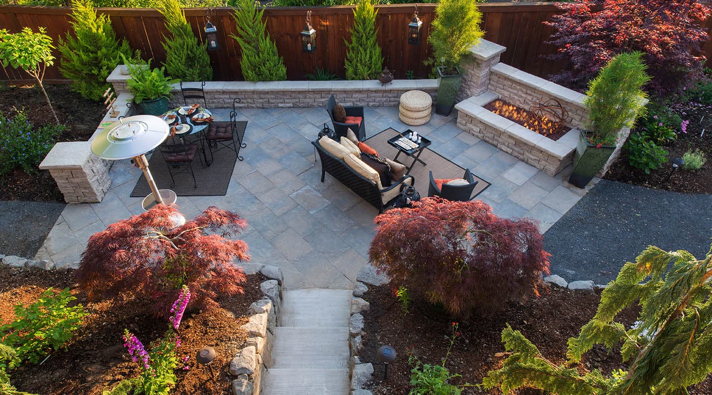 Backyard after the job: finished paver patio with seat walls and a fire pit