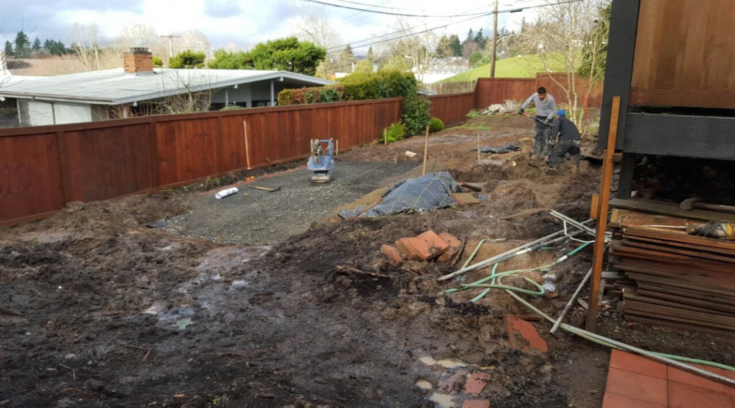 Backyard before the job: bare dirt and construction materials